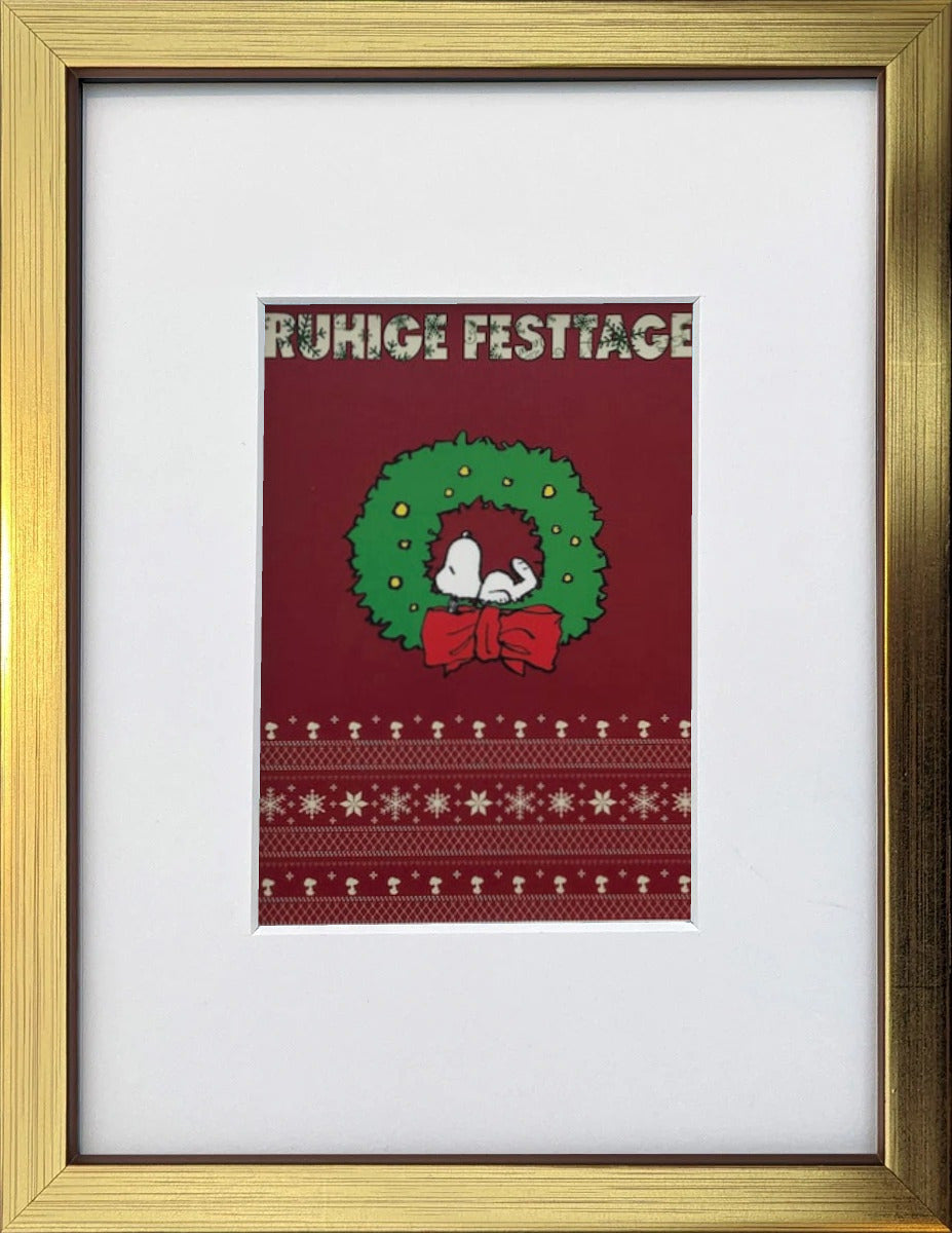UNICEF-Karte „Ruhige Festtage“ mit Snoopy im Weihnachtskranz als gerahmter Miniprint im goldenen Holzrahmen