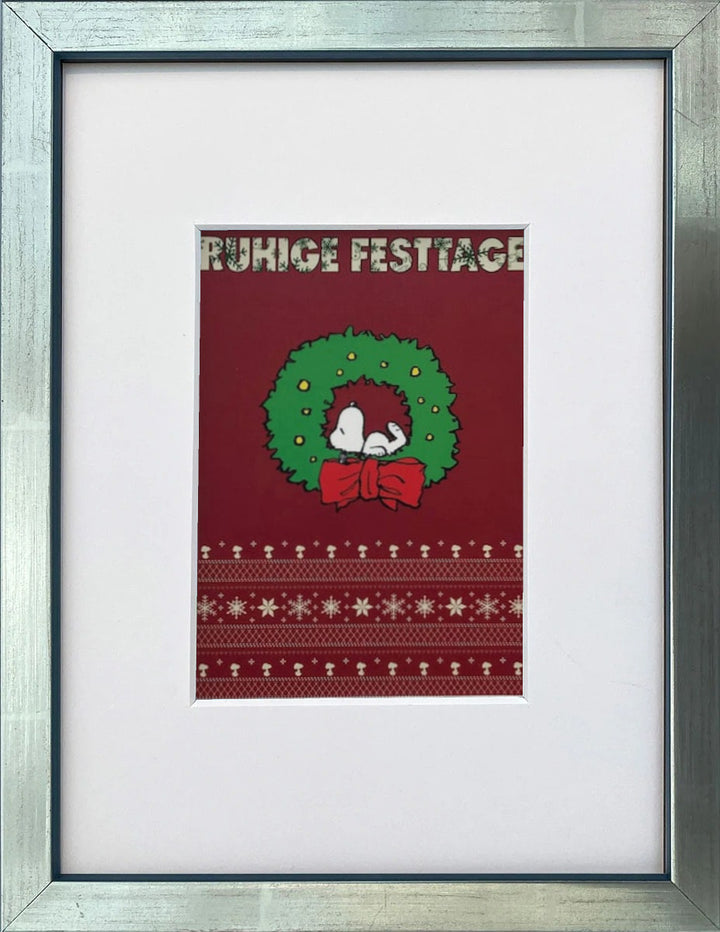 UNICEF-Karte „Ruhige Festtage“ mit Snoopy im Weihnachtskranz als gerahmter Miniprint im silbernen Holzrahmen