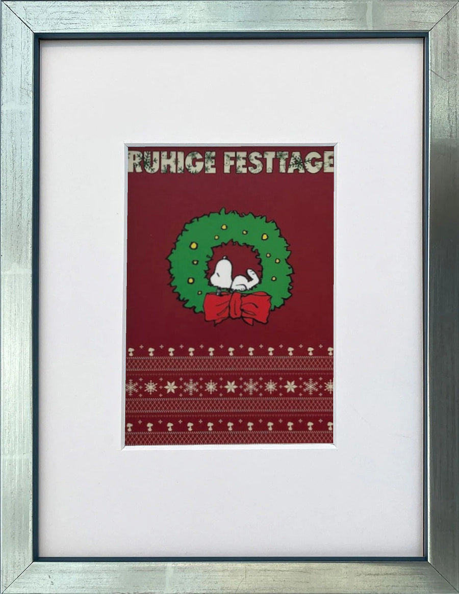 UNICEF-Karte „Ruhige Festtage“ mit Snoopy im Weihnachtskranz als gerahmter Miniprint im silbernen Holzrahmen